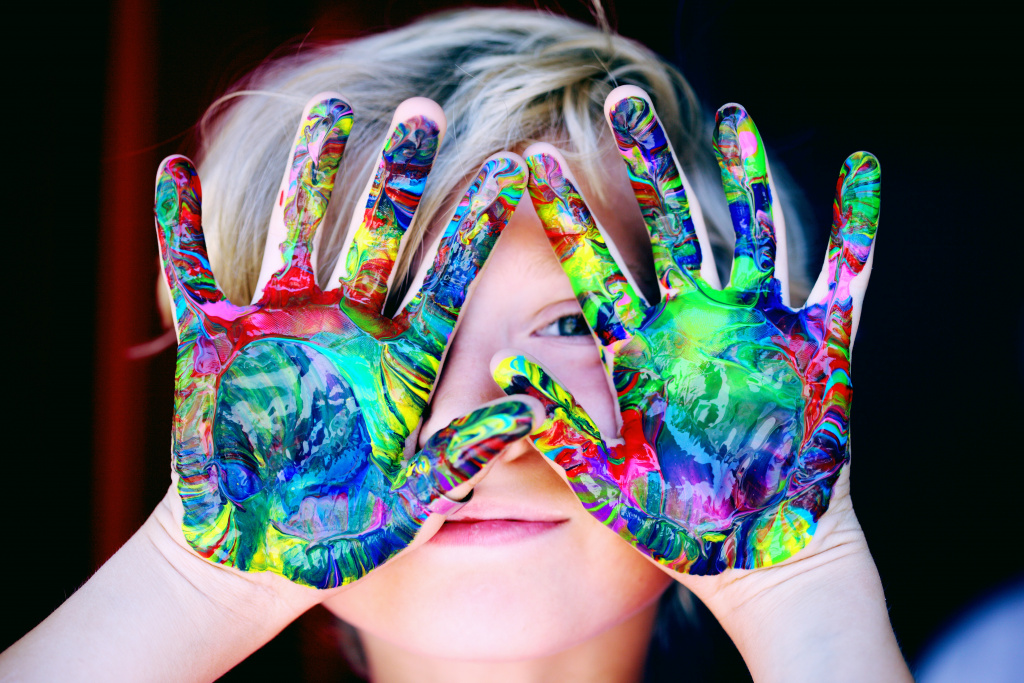 Barn med målarfärg på händerna