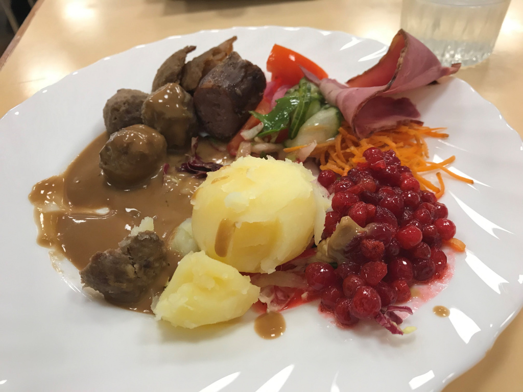 Tallrik med köttbullar, potatis, sås, lingon, rökt vildsvin och hjortkorv.