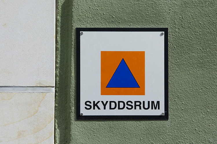 Skylt till skyddsrum har en blå triangel ovanpå en orange kvadrat